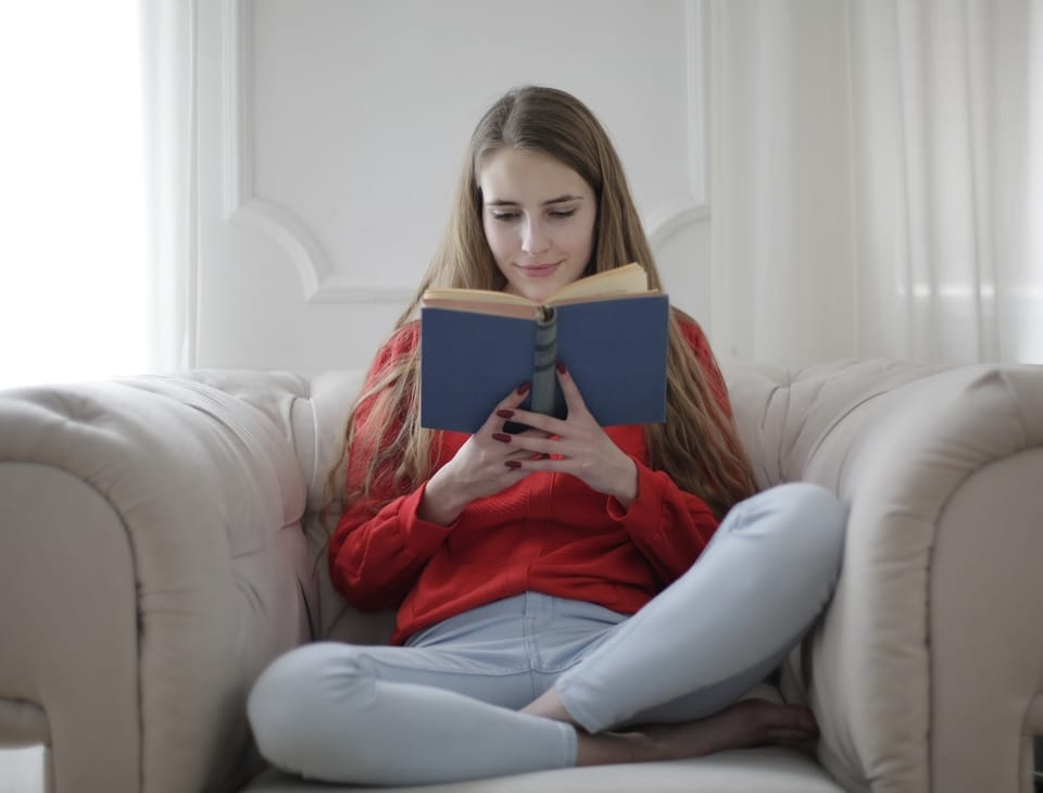 woman sitting in a chair reading a book